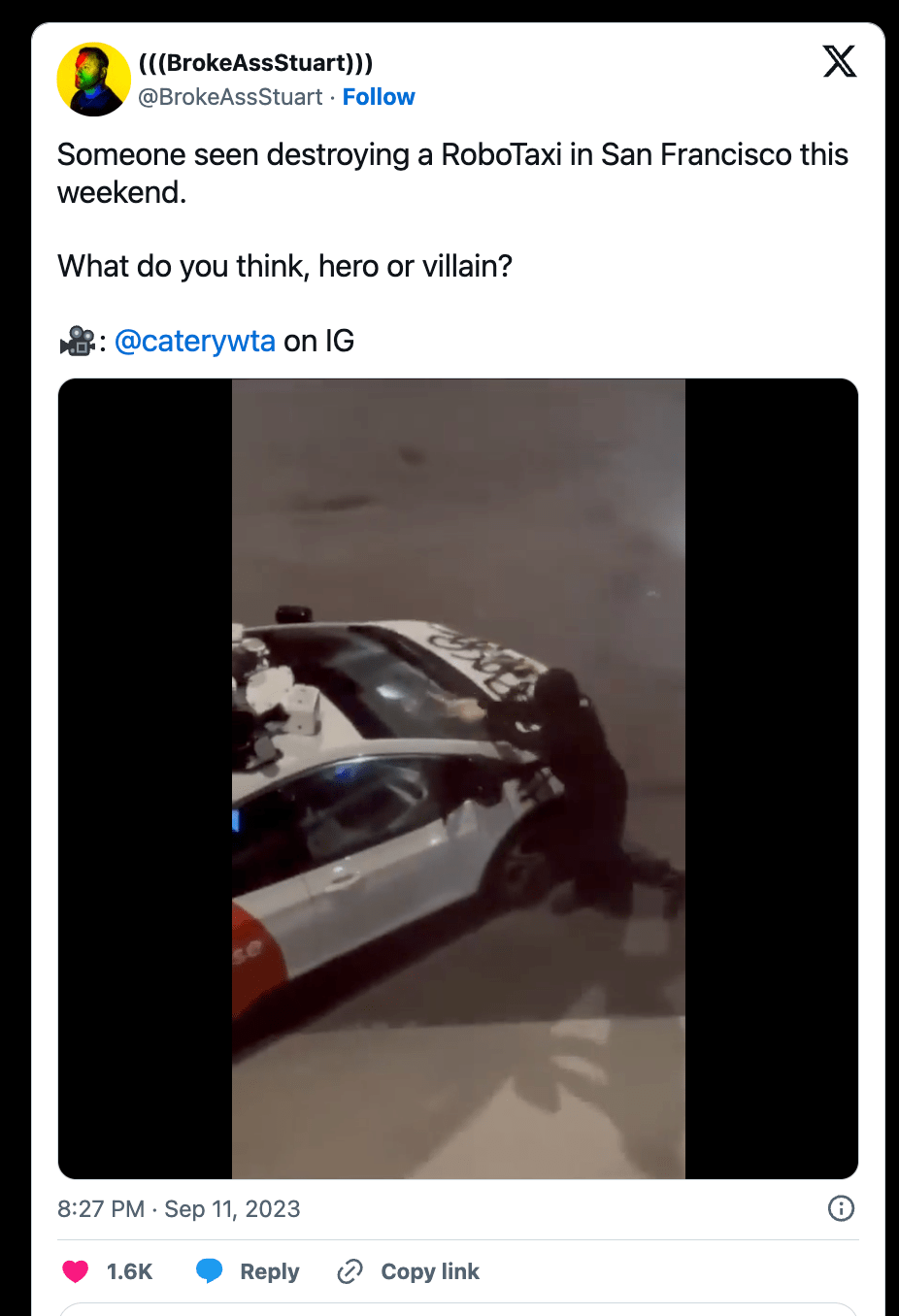 Someone showing an image of an individual hitting a RoboTaxi with a hammer.